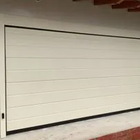 Porta sezionale per garage Serrmetall, modello Bidoga goffrato su misura ral 1013