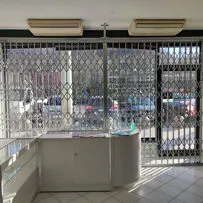 Cancello estensibile riducibile per protezione vetrina commerciale Serrmetall.