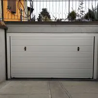 Porta basculante per garage realizzata in pannelli sandwich schiumati, finitura goffrata di colore bianco